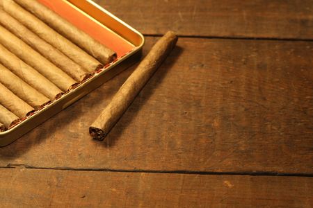 Closeup of cigars lying inside metal box on wooden backgroundの写真素材