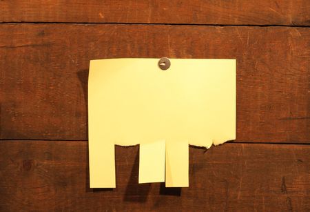 Yellow paper hanging on wooden background with thumbtacksの写真素材