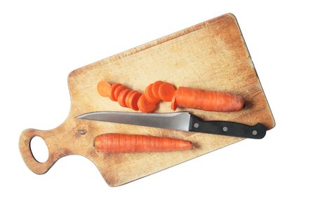 Sliced carrots and kitchen knife lying on breadboard.の写真素材
