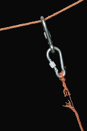 Two connected carabiners hanging on the disrupt rope.の写真素材