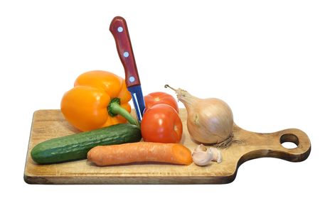 Various vegetables and knife on wooden breadboard isolated on whiteの写真素材
