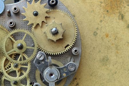 Closeup of old metal clock mechanism on yellow brass backgroundの写真素材