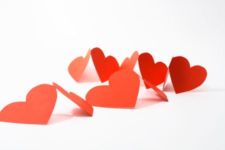 Abstract composition with red paper hearts on white backgroundの写真素材