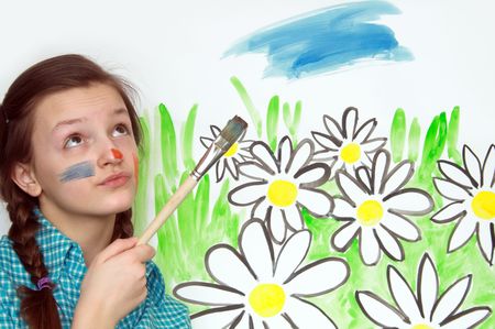 Young nice girl with brush on background with painted flowersの写真素材