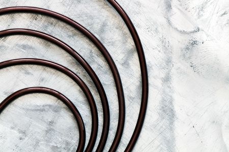 Spiral made from dark wire lying on light gray metal background with copy spaceの写真素材