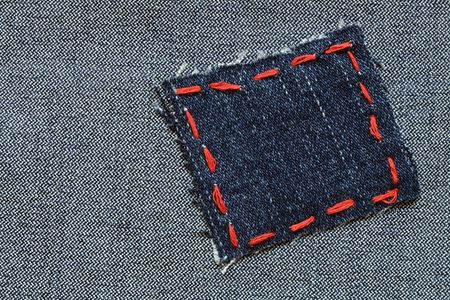 Patch with red thread attached on jeans texturedの写真素材