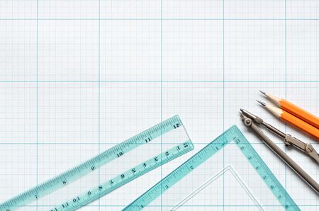 Divider, pencils and rulers on blue graph paper backgroundの写真素材