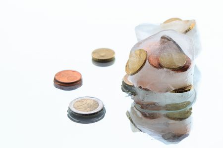 Coins inside ice cubes isolated on white backgroundの写真素材