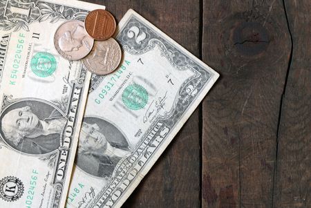 One and two old dollar bank notes and few coins on wooden backgroundの写真素材