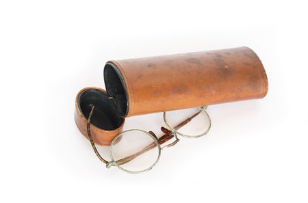 Old spectacles and vintage ginger leather case on white backgroundの写真素材
