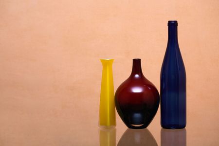 Three various glass motley vessels isolated on pink backgroundの写真素材