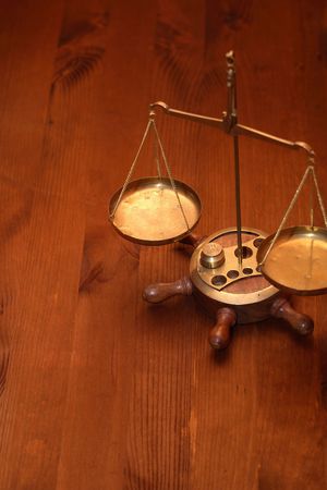 Ancient brass weight scale standing on nice wooden backgroundの写真素材