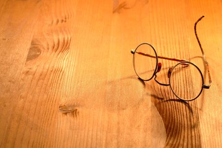 Vintage spectacles lying on nice yellow wooden backgroundの写真素材