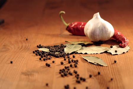 Bay leaves, head of garlic and peppercorns on wooden backgroundの写真素材