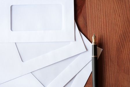 Few empty blank envelopes and fountain pen on wooden background