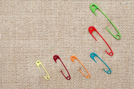 Few color safety pins attached to canvas backgroundの写真素材