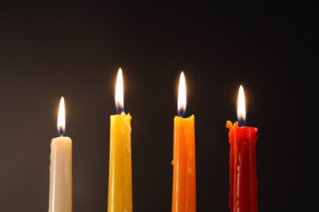 Set of four colored lighting candles on dark backgroundの写真素材