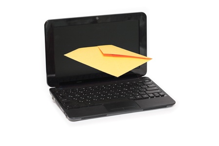 Yellow paper envelope inside screen of laptop on white backgroundの写真素材
