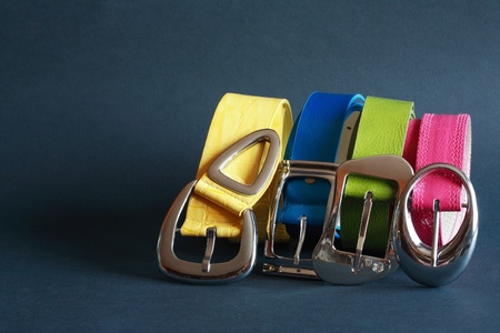 Few coloured leather belts in a row on dark backgroundの写真素材