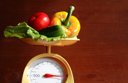 Still life with modern kitchen scale and vegetables on wooden backgroundの写真素材