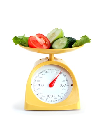 Sliced fruits and vegetables on kitchen scale. Isolated on white with clipping pathの写真素材