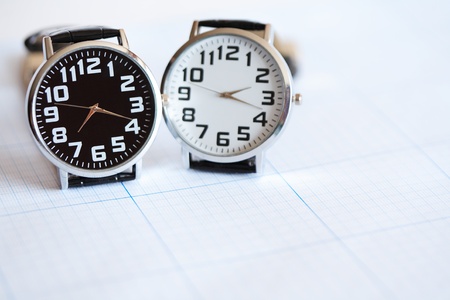Pair of modern wristwatches standing on graph paper surfaceの写真素材
