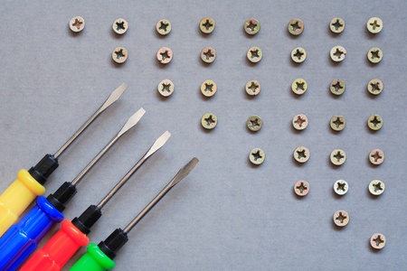 Industrial concept. Set of color screwdrivers near lot of screwsの写真素材
