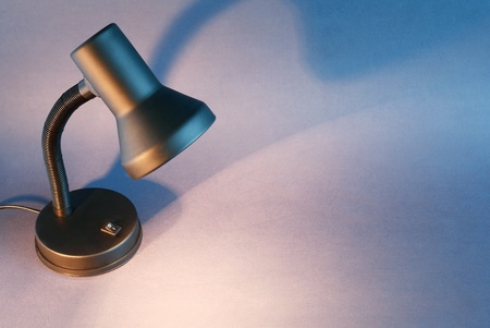 Black luminous desk lamp on dark background with copy spaceの写真素材