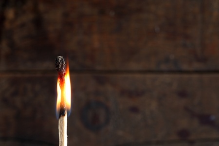 Closeup of one burning match on dark background