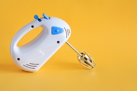 A new white electric mixer on yellow background with free space for textの写真素材