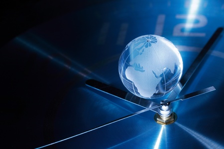 Time concept. Closeup of glass globe lying on blue metal clock faceの写真素材