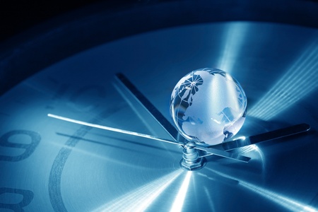 Time concept. Closeup of glass globe lying on blue metal clock faceの写真素材