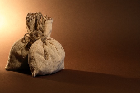 Storage concept. Two full burlap sacks on nice brown background with free space for textの写真素材