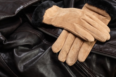 Pair of new female suede gloves with fur on leather backgroundの写真素材