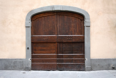 Fragment of old building with pink wall and nice wooden gate