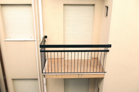 Closeup of small empty balcony with closed window and doorの写真素材