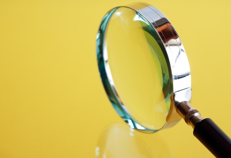 Closeup of magnifying glass on yellow backgroundの写真素材