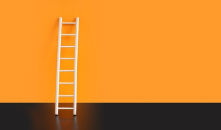 Wooden ladder on black floor against orange wall. Nice background with free space for textの写真素材