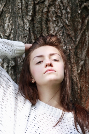 Portrait of beauty teenage girl on tree bark backgroundの写真素材