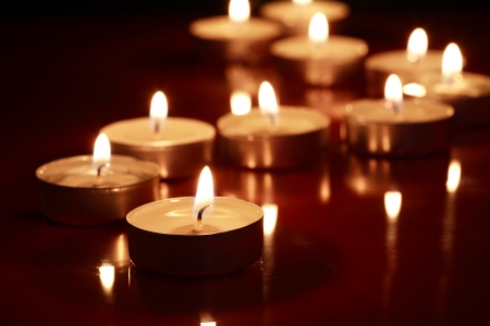 Set of lighting candles in a row on dark backgroundの写真素材