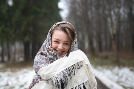 Beautiful young russian girl wearing traditional headscarf on forest backgroundの写真素材
