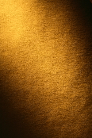Old yellow paper surface with beam of light. Good background for your textの写真素材