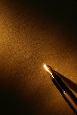 Closeup of stylish ink pen on paper surface with beam of lightの写真素材