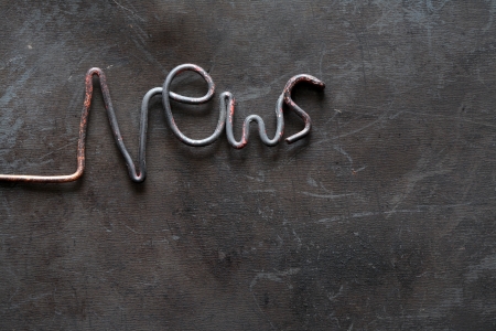 Periodical Press concept. Word News made from metal wire on grange dark backgroundの写真素材