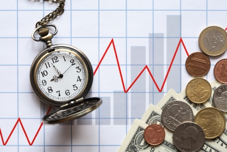 Business concept. Money and pocket watch on paper background with red chartの写真素材