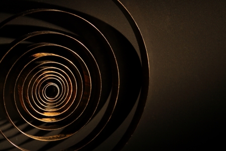 Rusty metal spring closeup of dark backgroundの写真素材