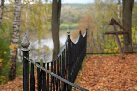 Fence of country graveyard in forest near riverの写真素材