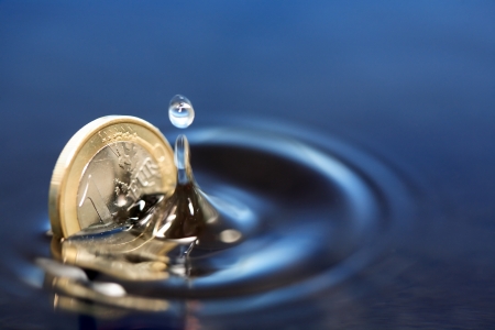 Closeup of one euro coin sinking in water with splashの写真素材
