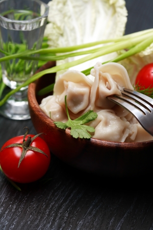 Still life with ravioli or pelmeni near vodka and vegetablesの写真素材