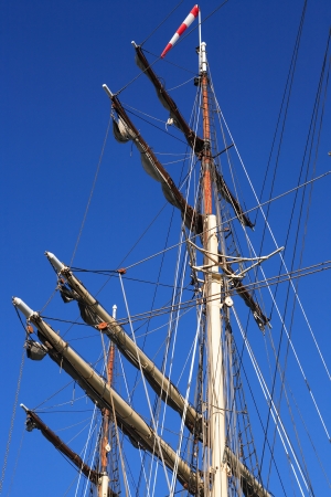 Sailing ship mast and rigging against blue sky